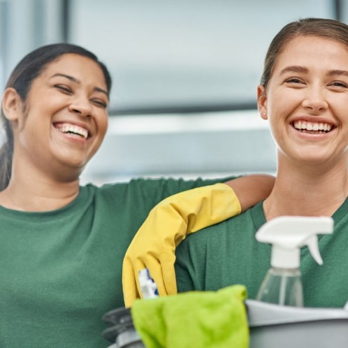 Portrait of two young woman cleaning a modern office Portrait of two young woman cleaning a modern office